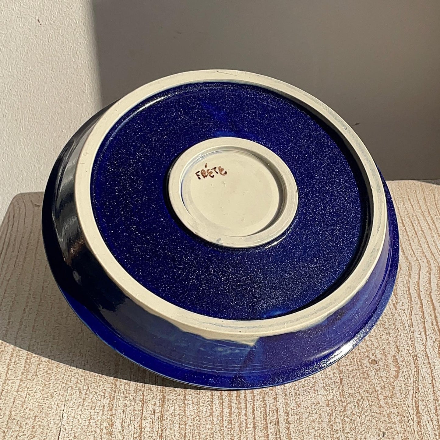 Blue ceramic plate with a textured surface on a wooden surface