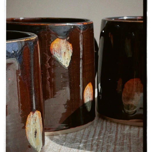 Three ceramic mugs with a textured finish on a neutral background