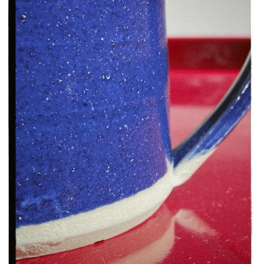 Close-up of a blue and white textured mug on a red surface