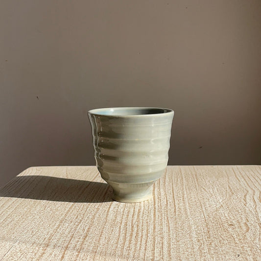 blue ceramic cup on a wooden surface with a brown background