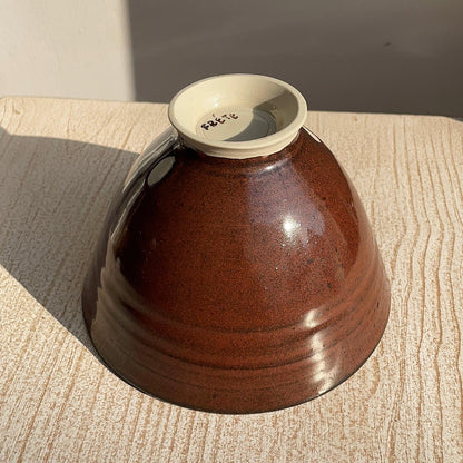 red ceramic bowl on a wooden surface