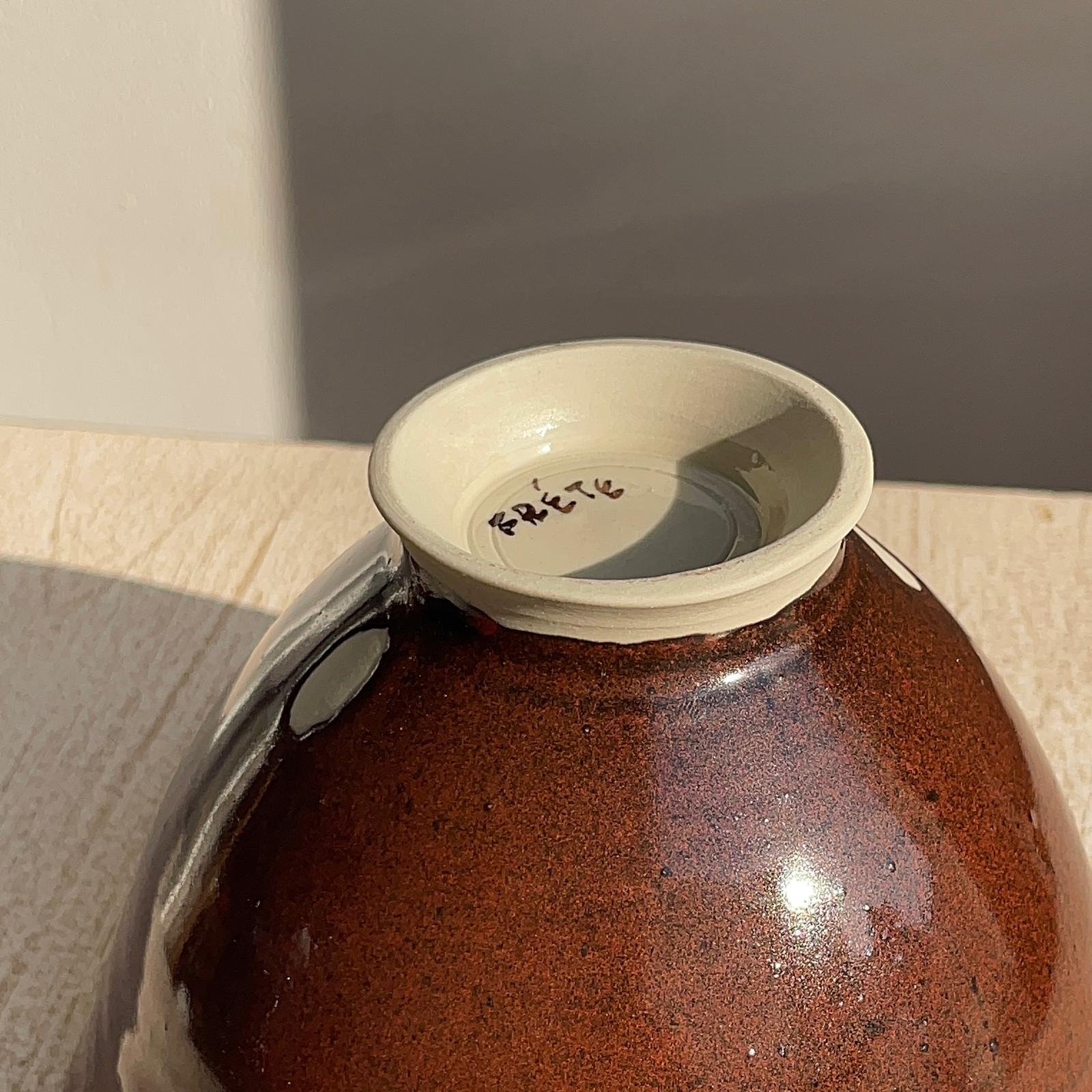 Close-up of a ceramic bowl with a featuring the brand 'FRÉTE'.