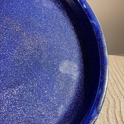 Close-up of a blue speckled plate on a wooden surface