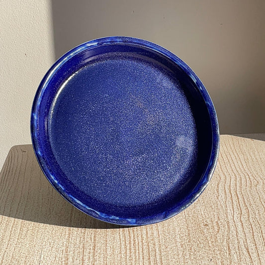 cobalt blue ceramic plate on a beige surface