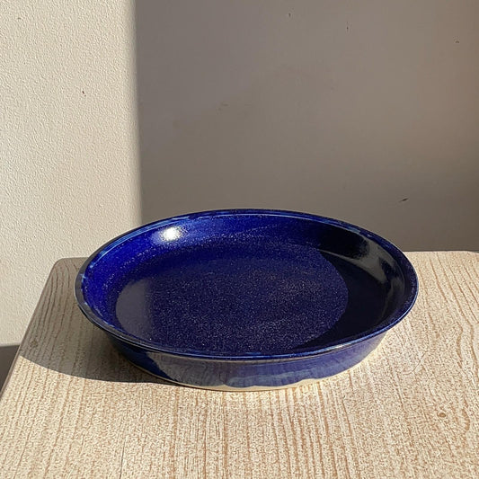 Blue ceramic plate on a textured surface with a neutral background