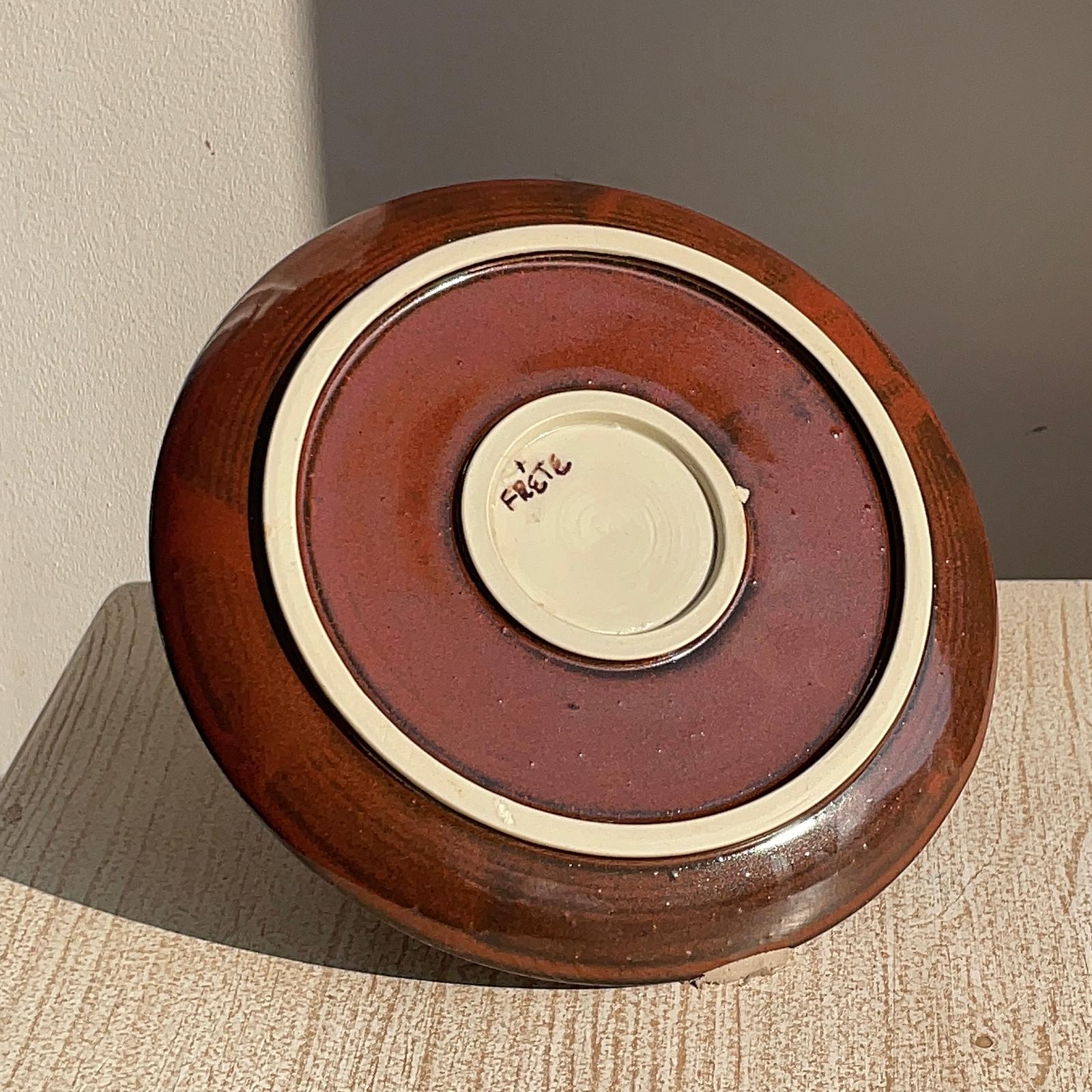 Round ceramic plate on a textured surface.
