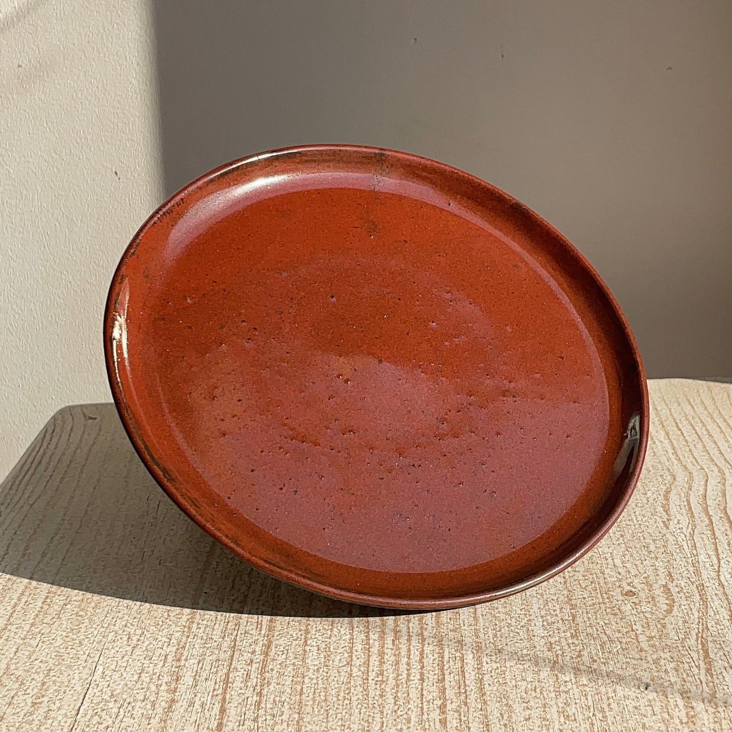 red ceramic plate on a textured surface with a neutral background