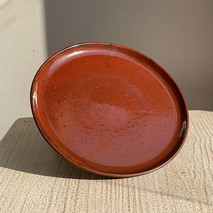 red ceramic plate on a textured surface with a neutral background