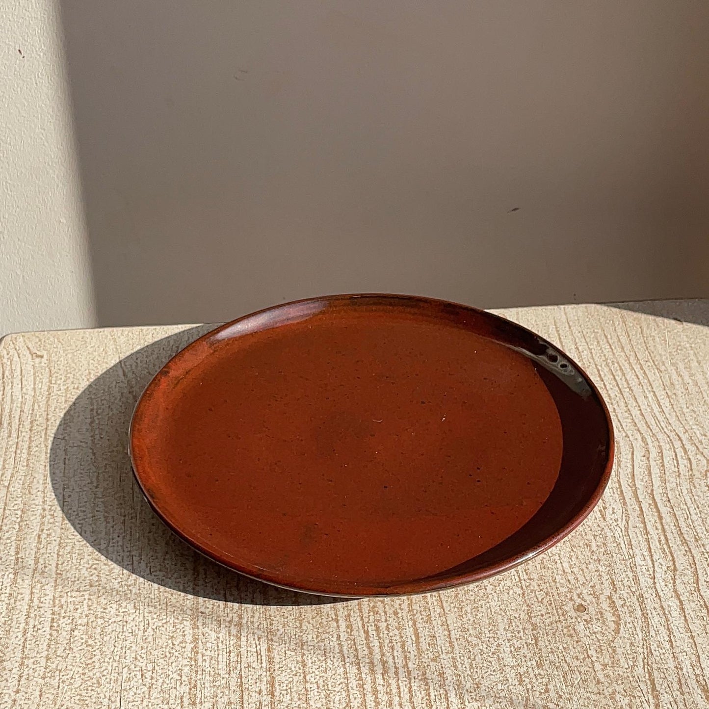 red ceramic plate on a textured surface with a neutral background