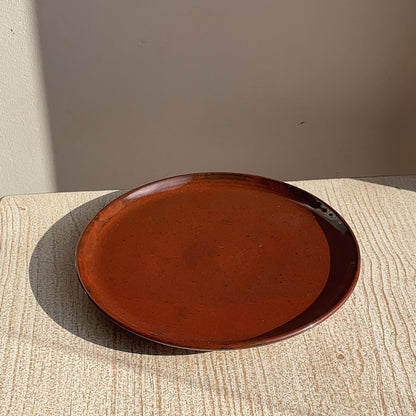 red ceramic plate on a textured surface with a neutral background