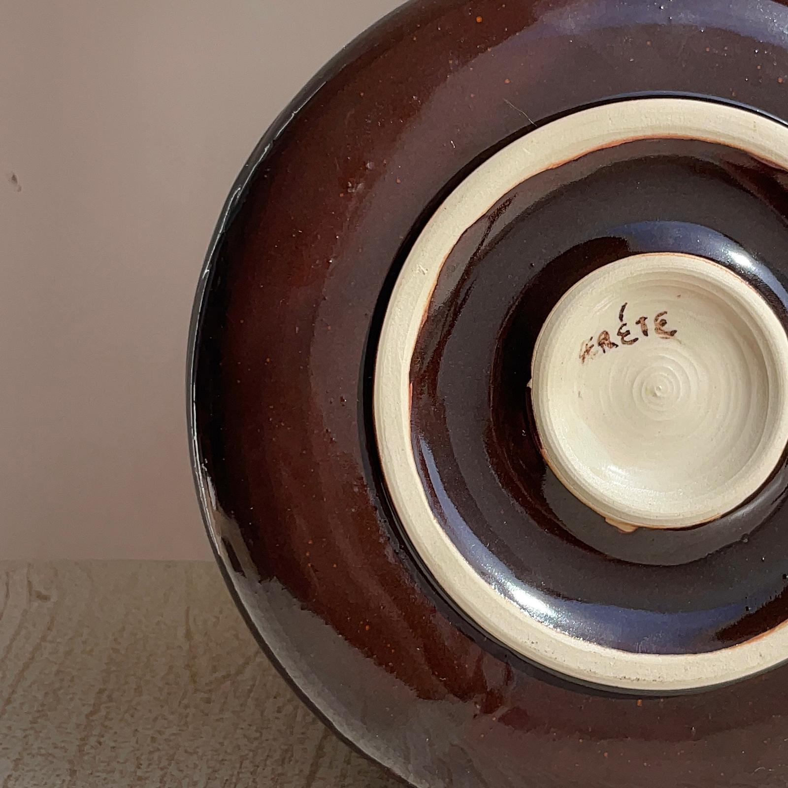 Ceramic plate with a dark brown exterior , featuring the brand 'Frete'.