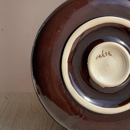 Ceramic plate with a dark brown exterior , featuring the brand 'Frete'.