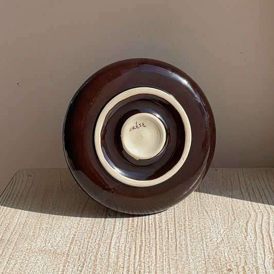 Brown ceramic plate on a wooden surface