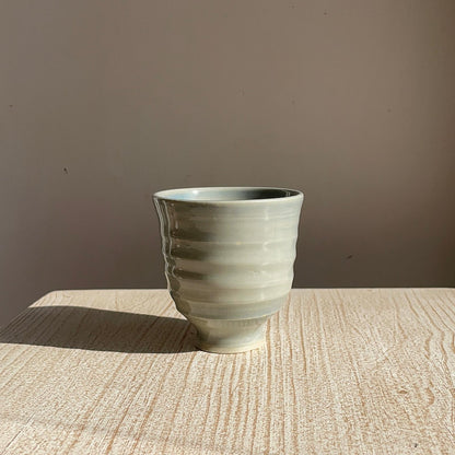 blue ceramic cup on a wooden surface with a brown background