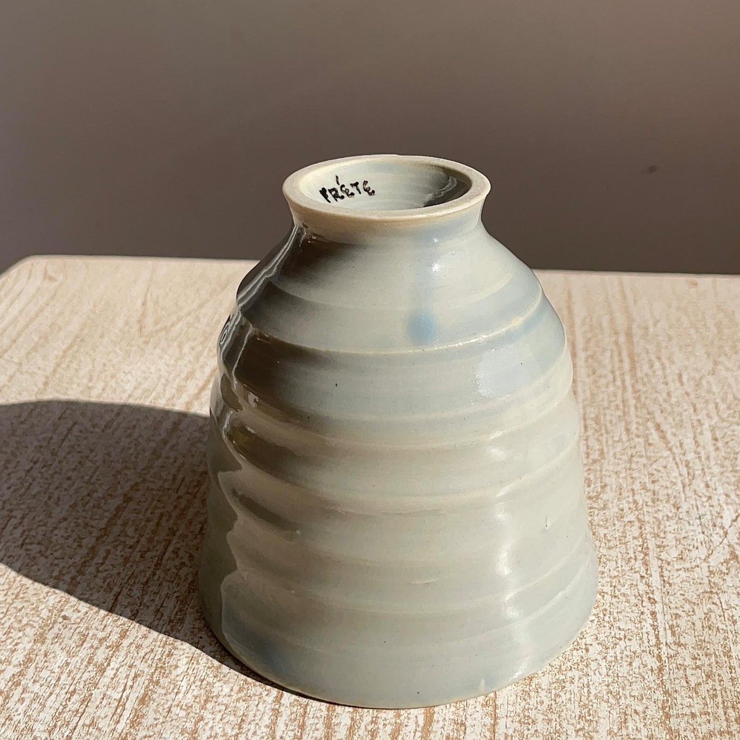 Ceramic cup with textured surface on a wooden surface