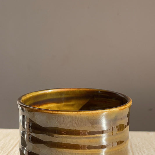 Ceramic cup with ribbed texture on a neutral background