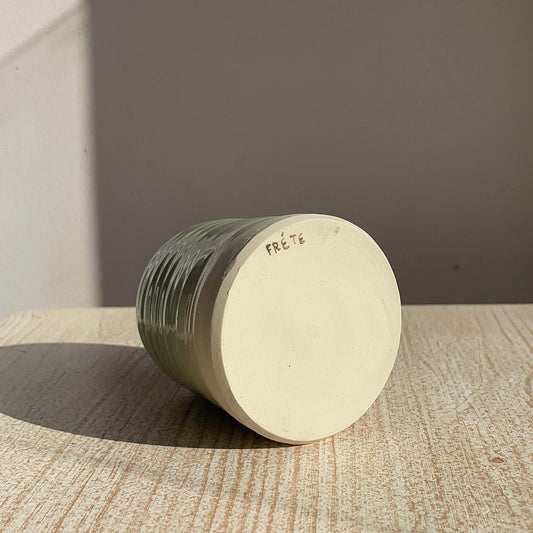 cup with 'Frete' branding on a wooden surface