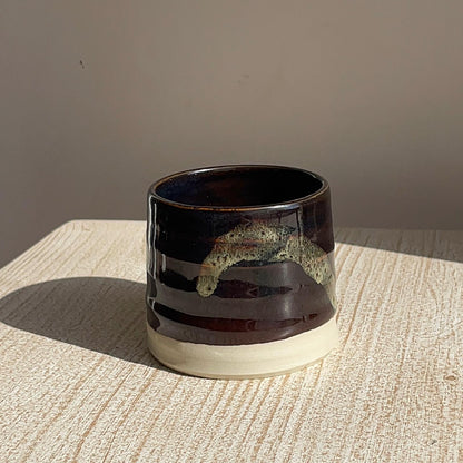 Ceramic cup with a two-tone design on a textured surface