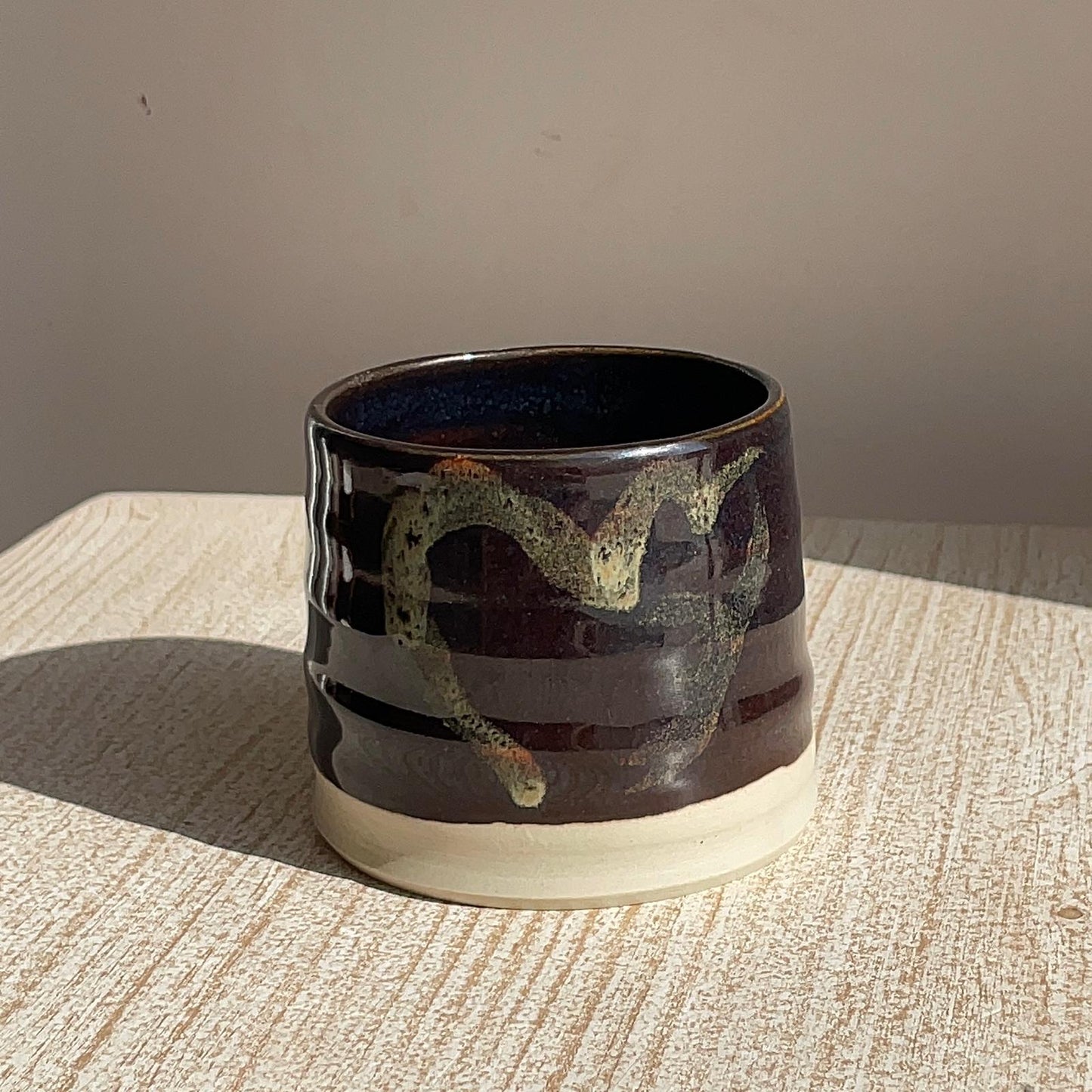 Ceramic cup with decorative design on a textured surface