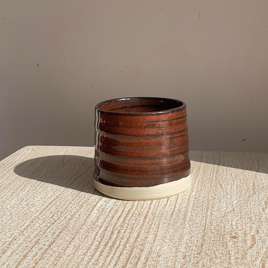 red cup on a textured surface with a neutral background