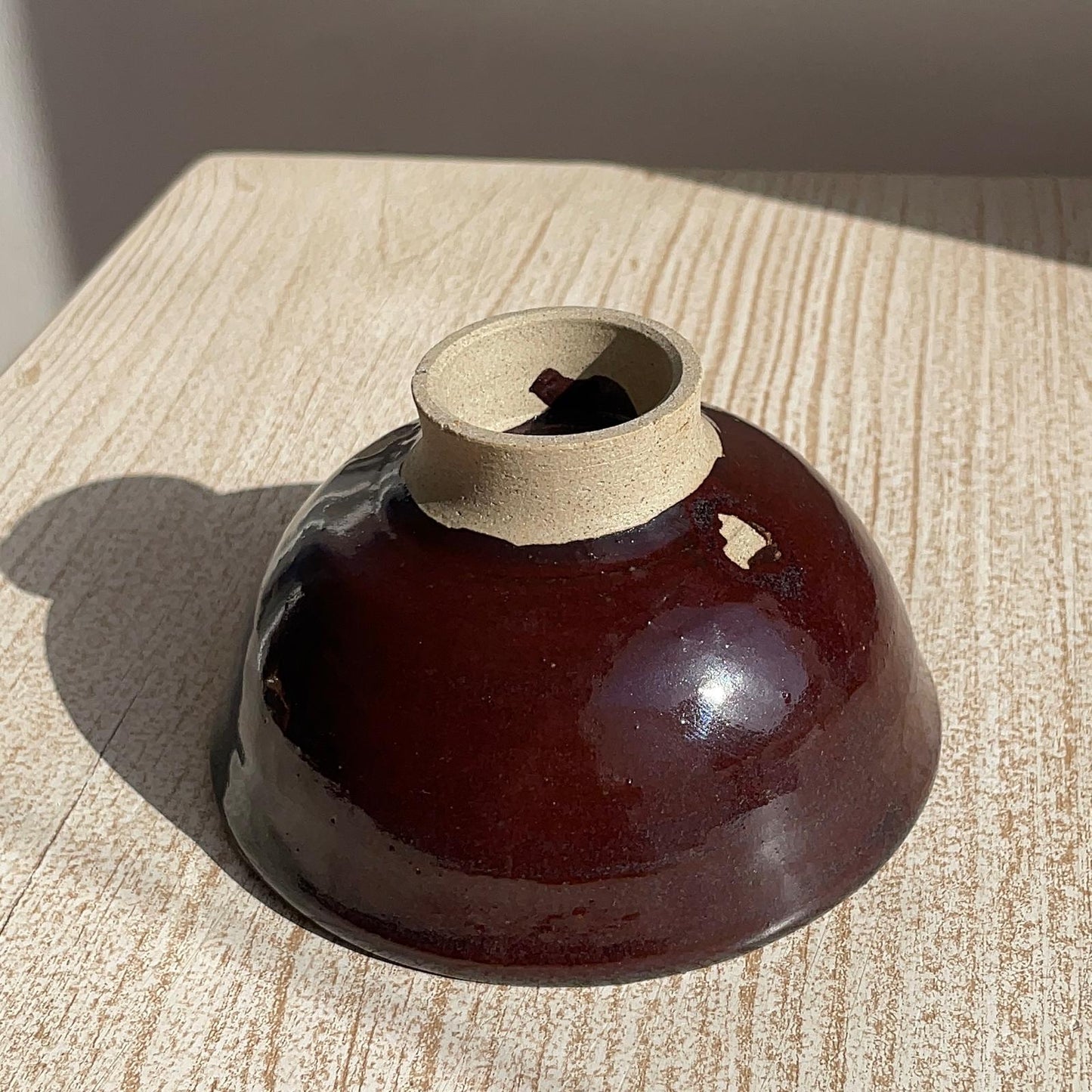 Brown ceramic bowl with a textured surface on a wooden table