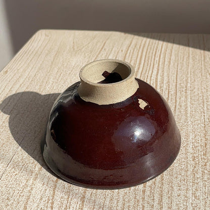 Brown ceramic bowl with a textured surface on a wooden table