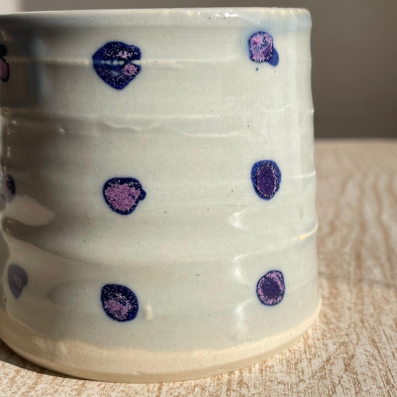 cup with purple and blue polka dots on a wooden surface