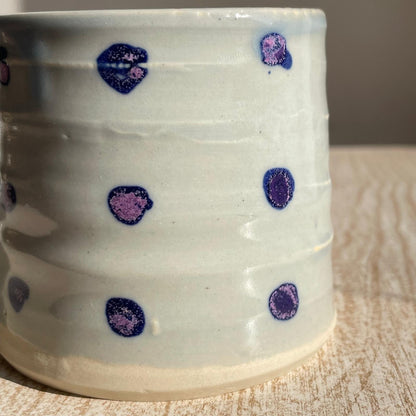 cup with purple and blue polka dots on a wooden surface
