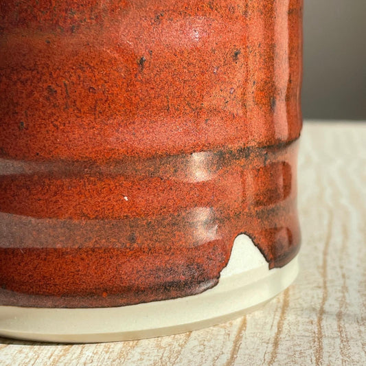 Close-up of a red ceramic cup on a wooden surface