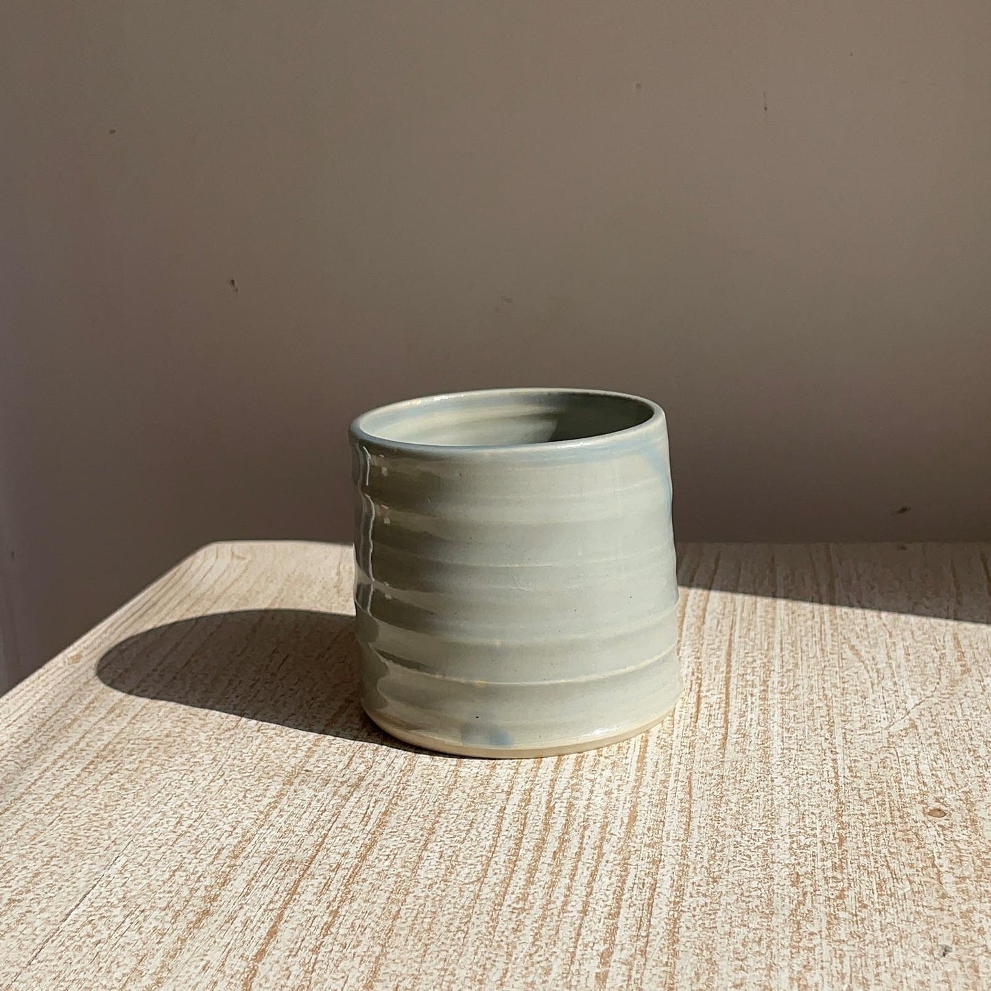 blue ceramic cup on a textured surface with a plain background