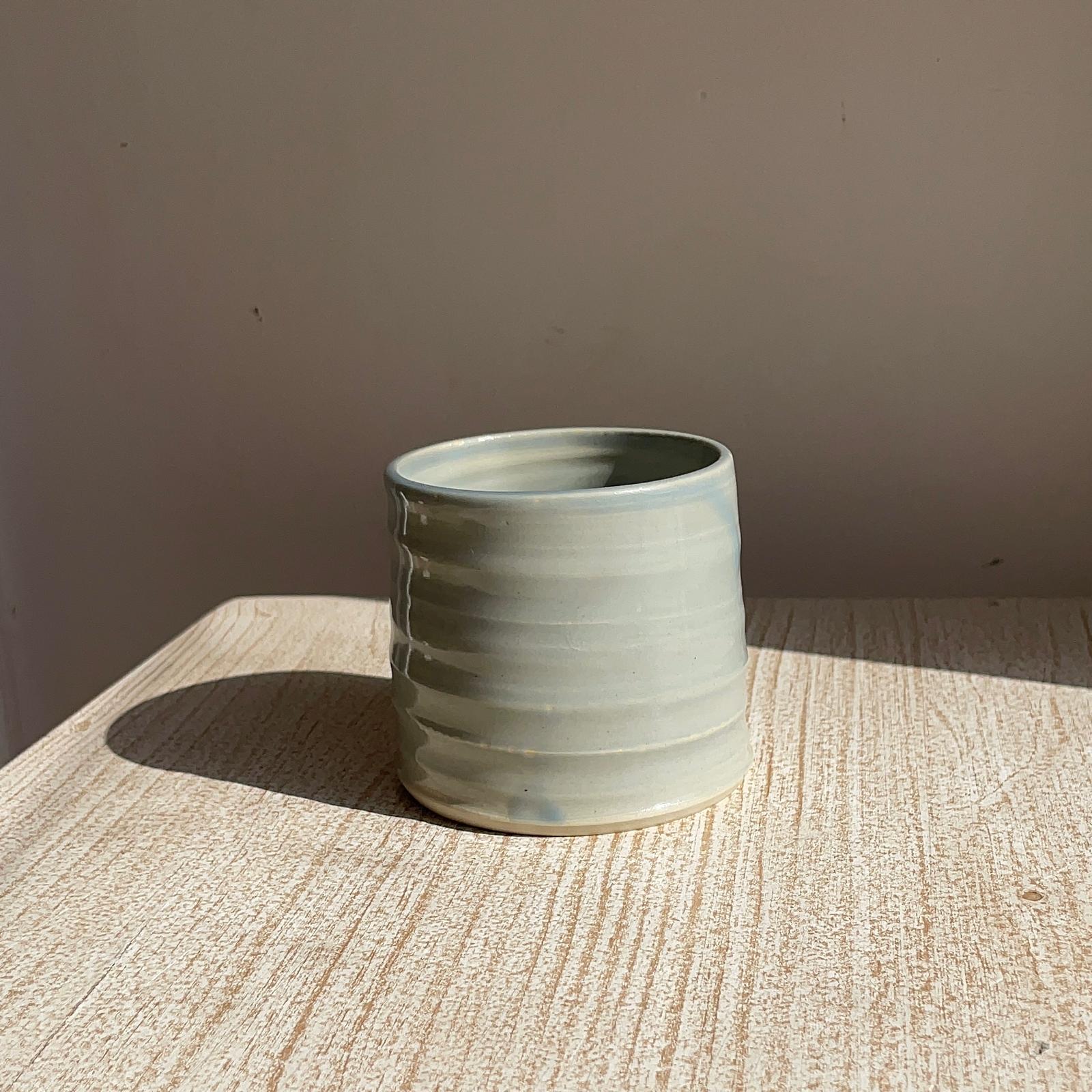 blue ceramic cup on a textured surface with a plain background