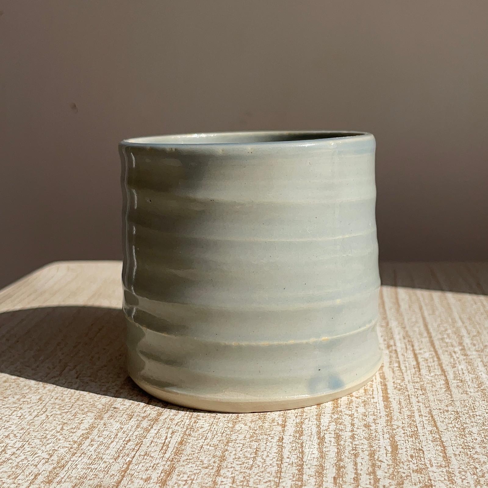 Ceramic cup with textured surface on a wooden surface