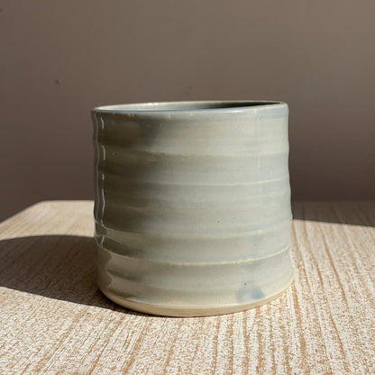 Ceramic cup with textured surface on a wooden surface